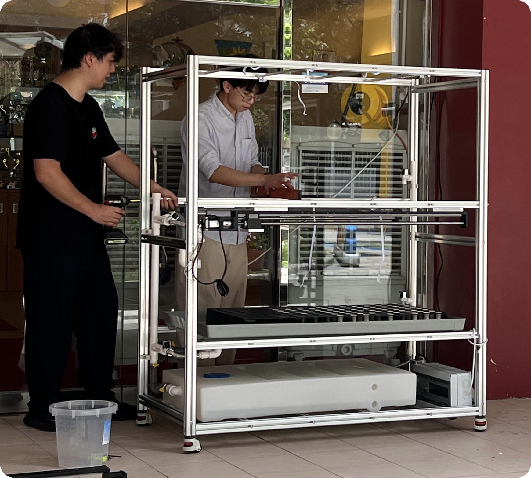 Two engineers assembling a custom hydroponic grow rack